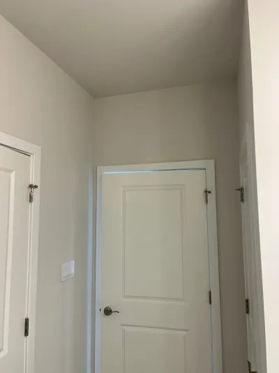 A freshly painted hallway with a white paneled door and visible door frames on either side.