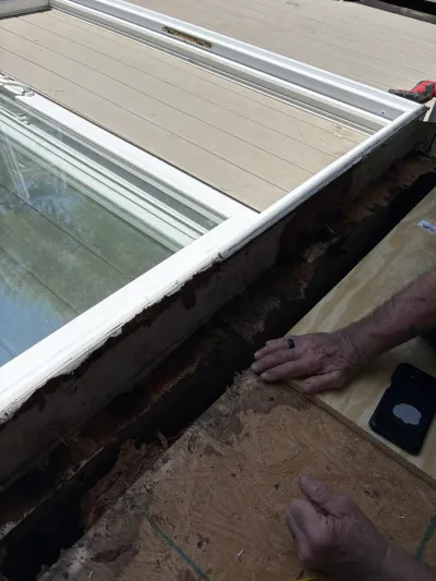 Close-up of a skylight repair showing rotted roof decking being replaced with new plywood sheathing.